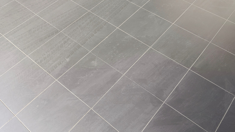 A grey tile floor with fine white grout lines