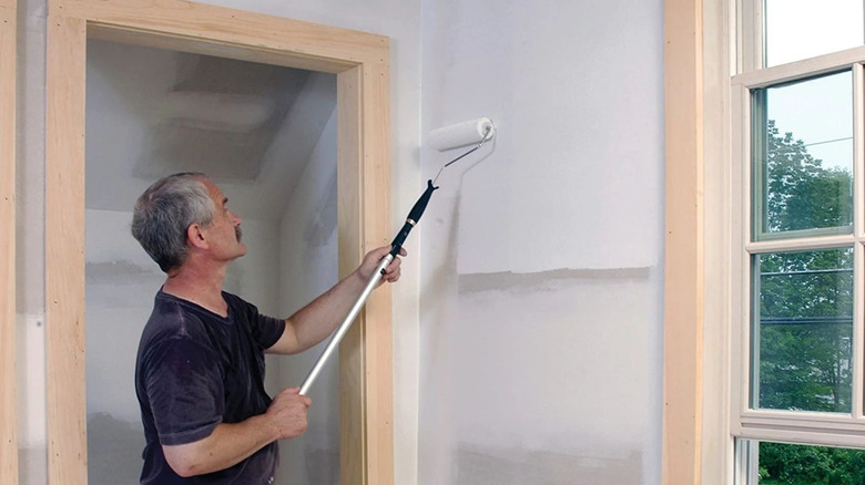 Hand painting white wall yellow with a roller