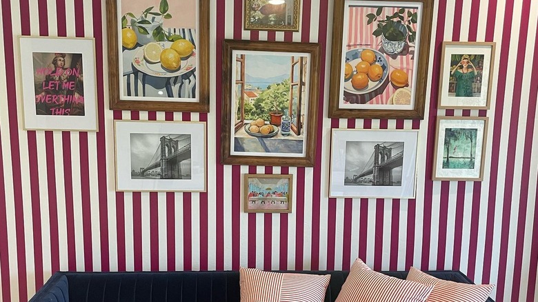 Thin striped gallery wall behind dark blue sofa