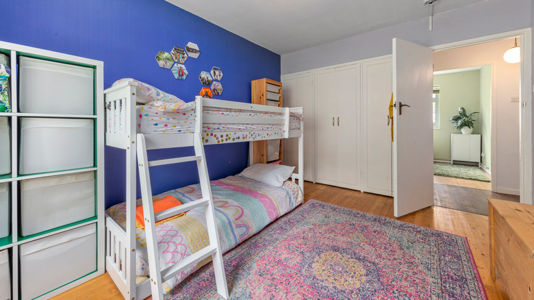 Whimsical kids' room with bold blue wall and bright rug