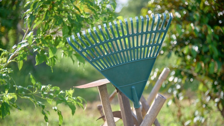 The head of a plastic leaf rake with other tools