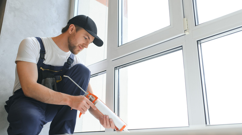 man putting new windows in a house