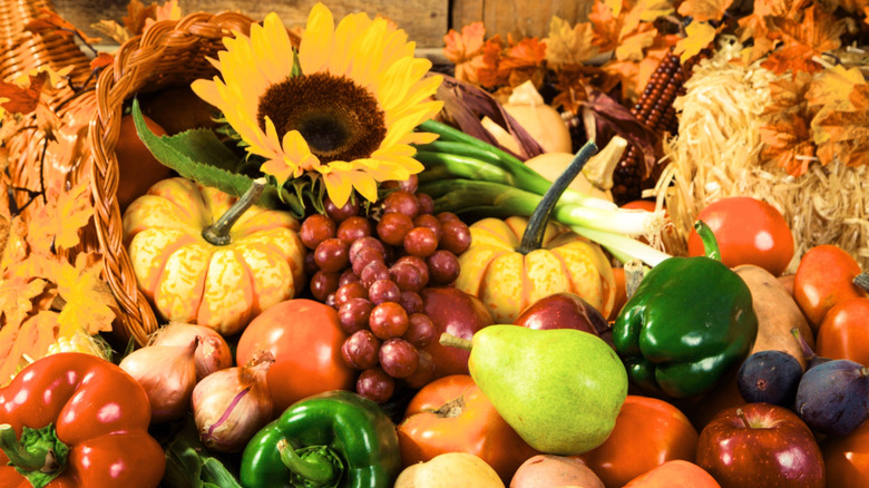 A cornucopia filled with fresh produce and flowers spilling out around the basket