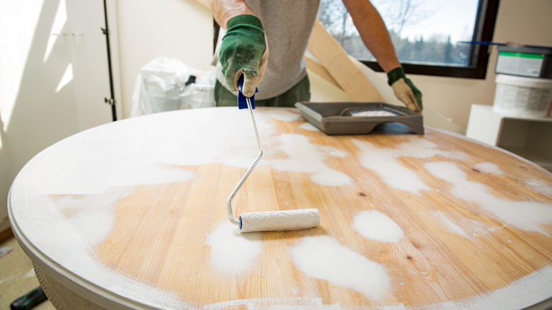 hand rolling paint onto furniture