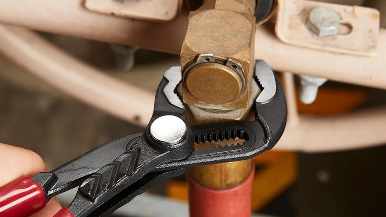 Person using locking pliers on a bolt