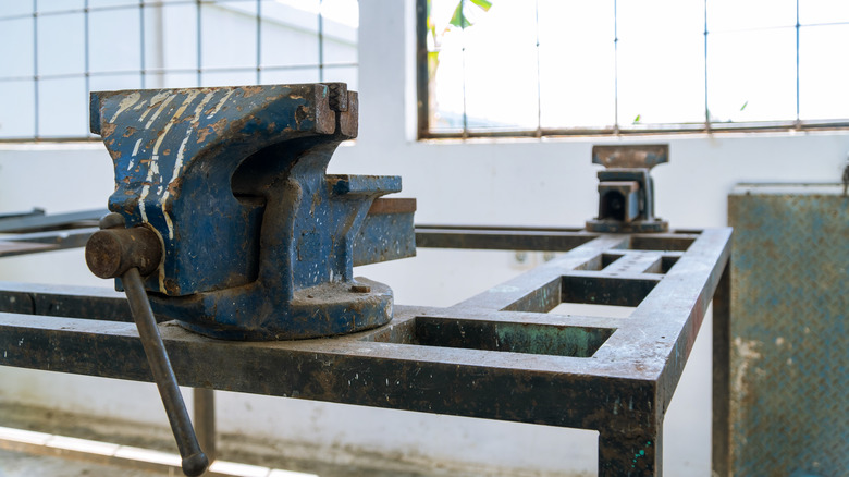 heavy duty bench vise in a bright workshop with large windows