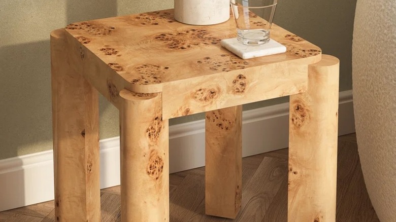 Maple burl end table placed by a chair