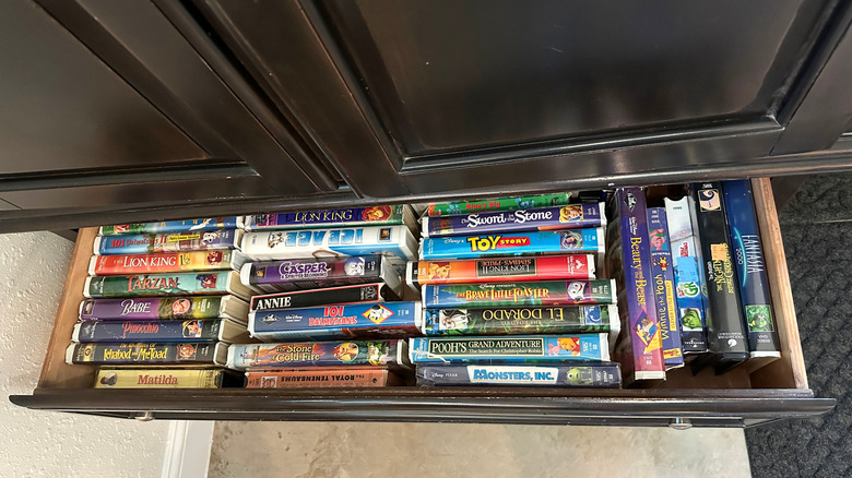 Collection of Disney animated movies and other children's films on VHS in a drawer