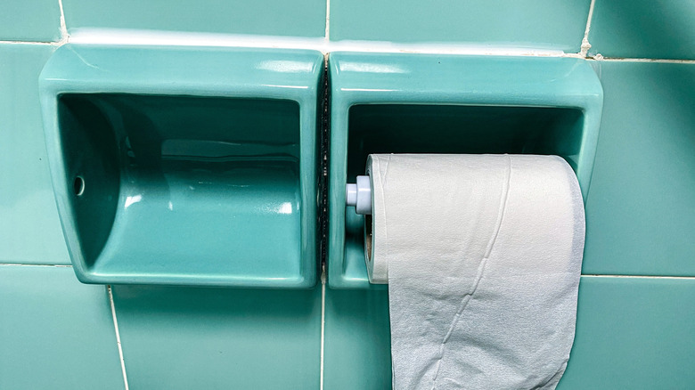 recessed toilet paper holder with green tile