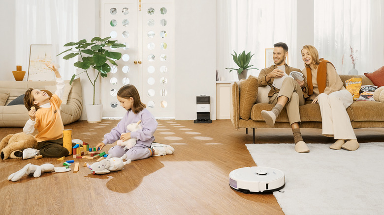 Roborock S8 ultrasonic robot mop cleaning a rug around children playing with toys