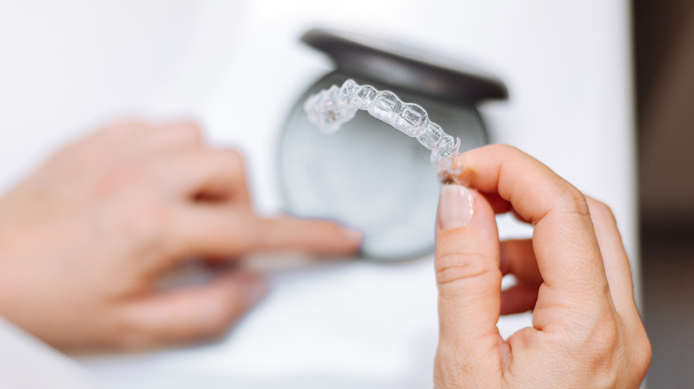 Person holding a retainer before cleaning