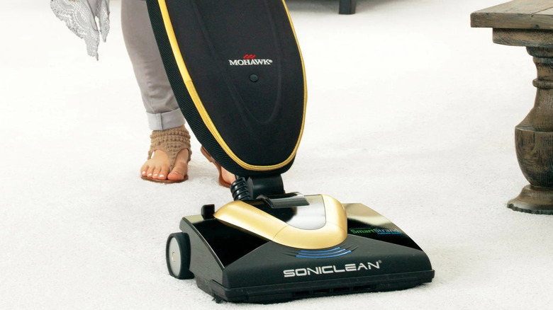 Woman using an ultrasonic vacuum from Sonic Clean to vacuum carpeting