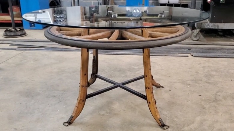 Glass and wood side table made from old wagon wheel