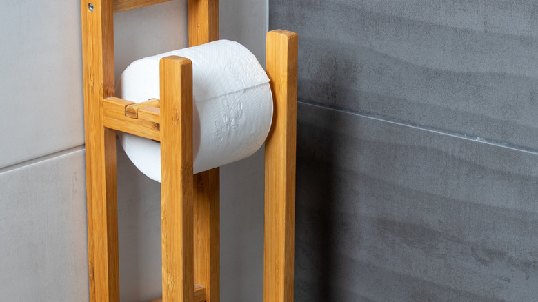 A wooden toilet paper holder.