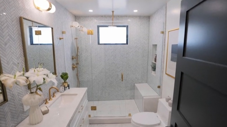 A white master bathroom with gold fixtures.