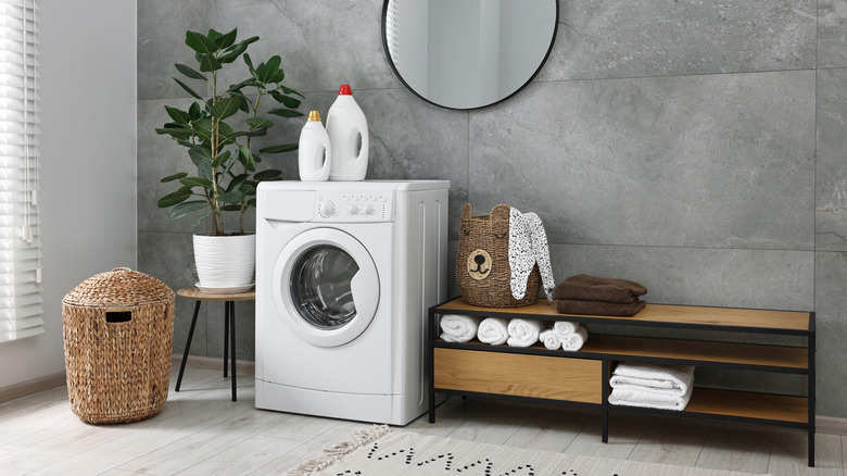 A storage bench in a laundry room holds linens and a clothes bin.