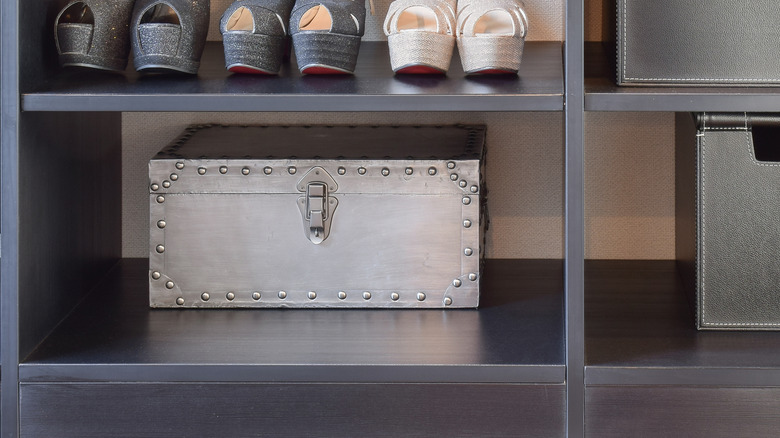 A shoe storage bench fitted into a large closet holds shoes and other personal items.