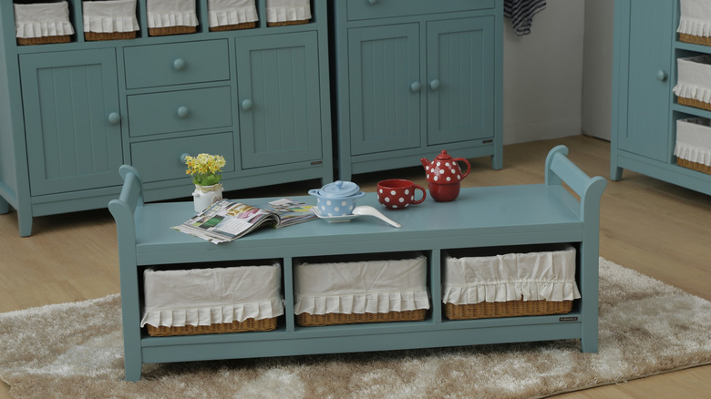 A shoe storage bench with baskets used as a coffee table in the living room.