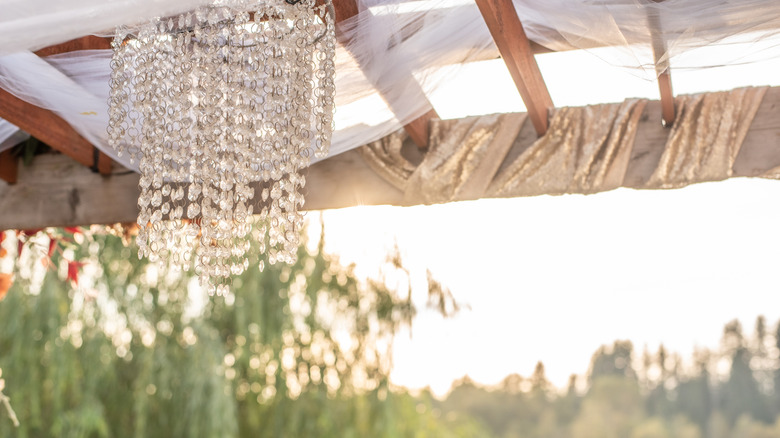 Crystal chandelier hanging outside from a pergola