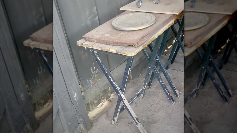 Used wooden TV tray table outside next to a fence