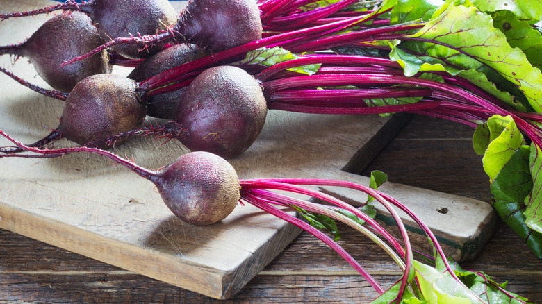 Freshly picked beets on a wooden cutting board