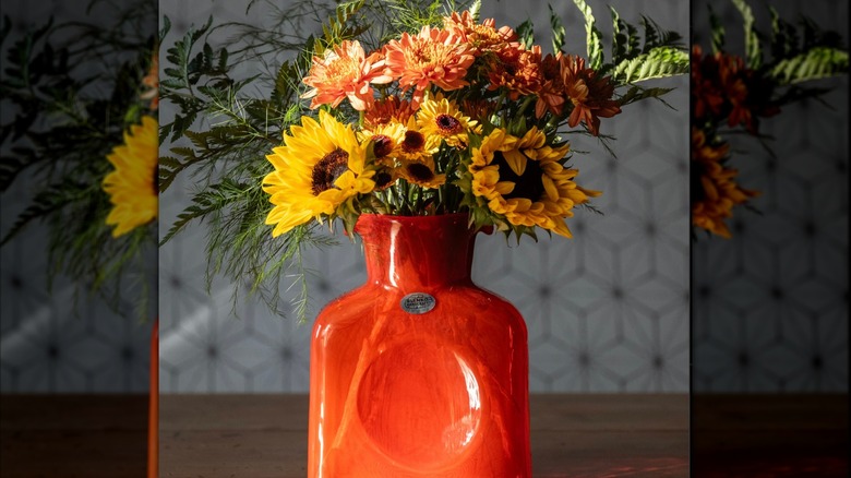 Orange glass vase filled with wildflowers