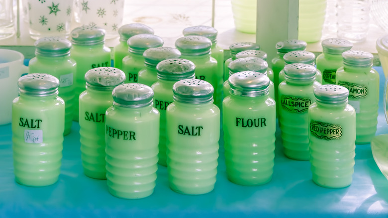 A large collection of jadeite spice shakers sits on a table
