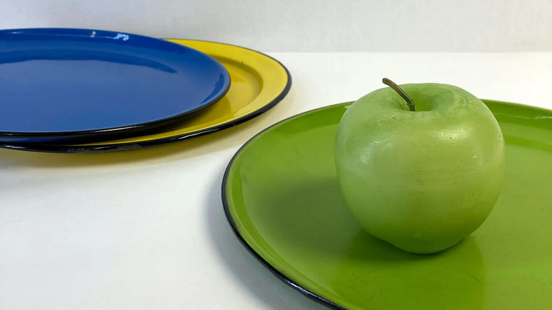 A green apple sits on a green Japanese OTO enamelware plate