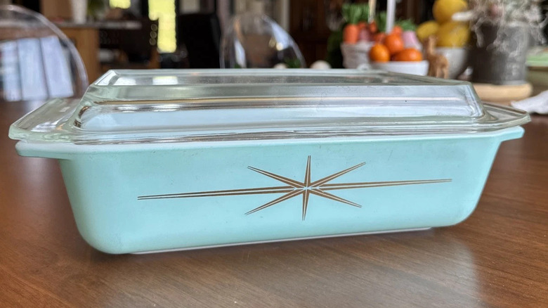 A Pyrex Atomic Starburst Casserole Dish sits on a wooden table
