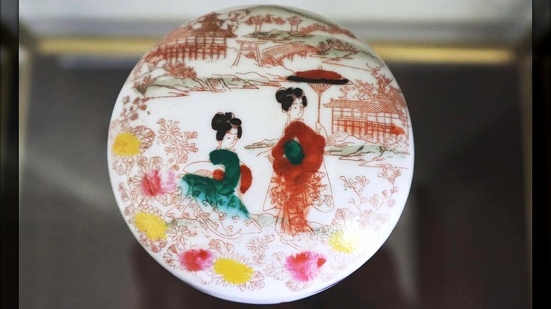 A rare and beautiful Nippon powder jar hand-painted with Geishas surrounded by Japan landscape