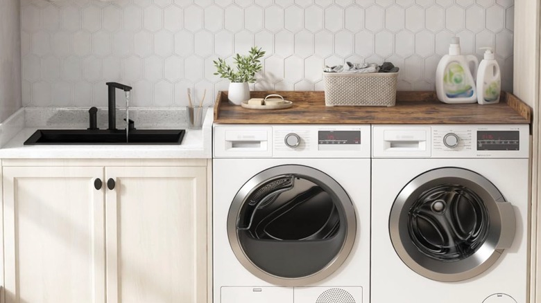 Rustic wood washer and dryer countertop with laundry soap.