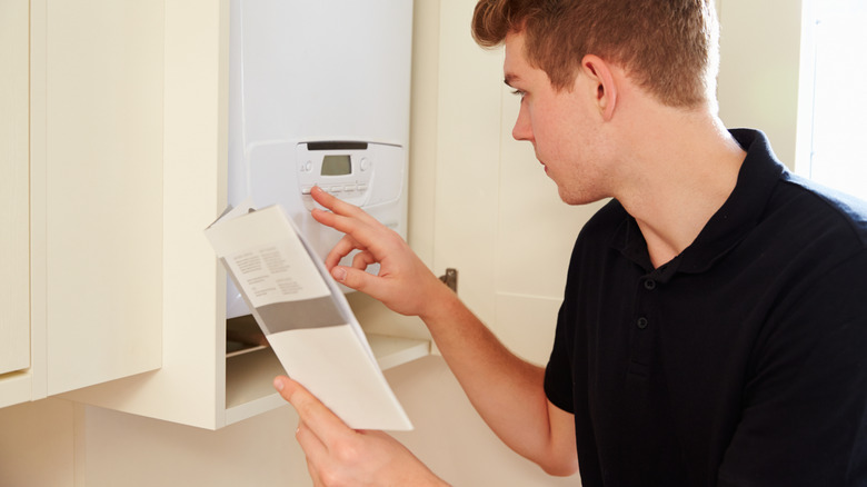 Person reviewing a water heater manual