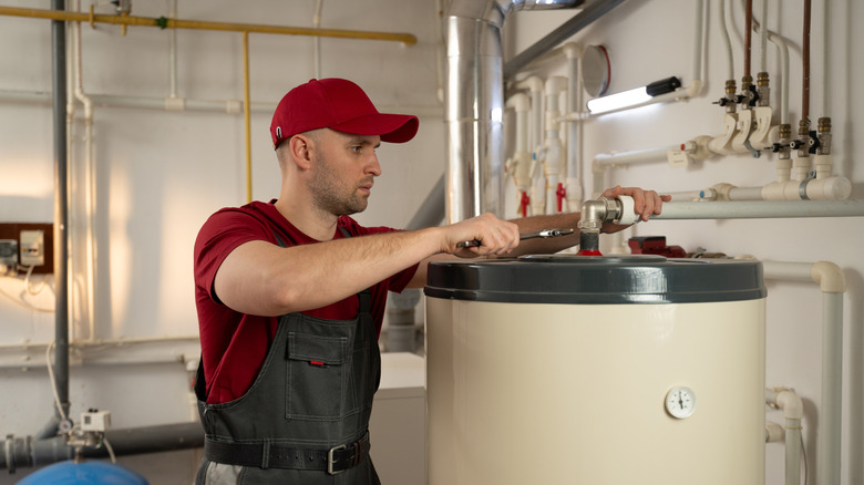 Professonal fixing a water heater in a basement