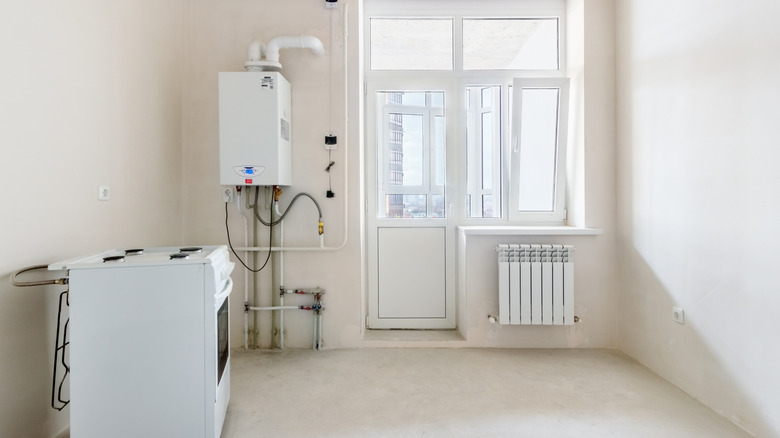 empty laundry room with a washing machine and small water heater
