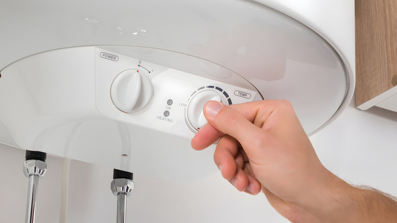 Hand setting the temperature on an indoor water heater