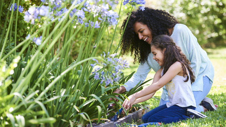 mother and daughter tending garden