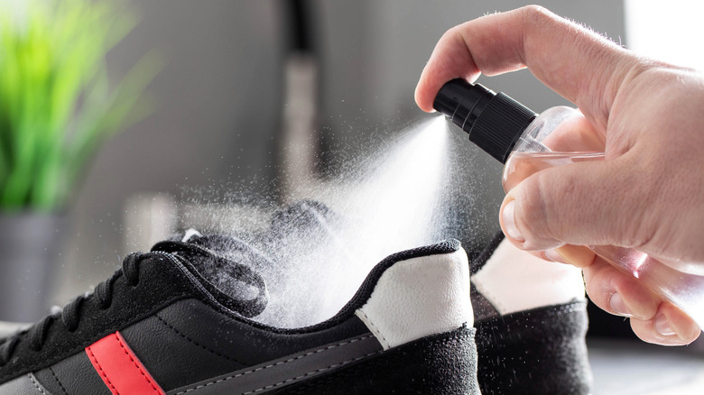 Black shoes being sprayed with a clear liquid