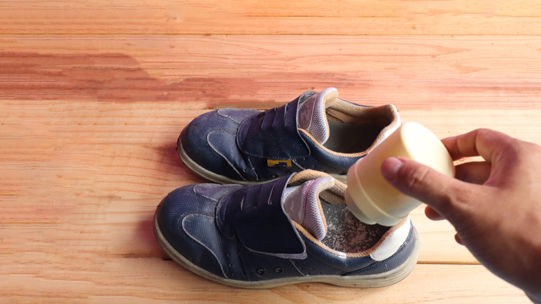 Foot powder being sprinkled in shoes