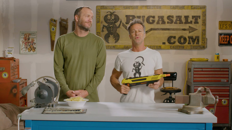 Two people demonstrating the Bug-A-Salt gun