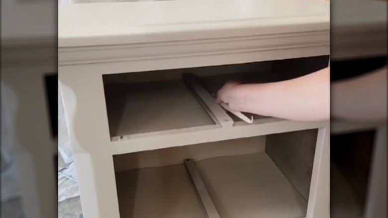 person applying candle wax to drawer