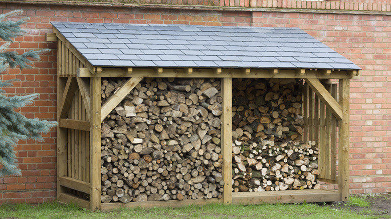 A firewood shelter against a garden wall