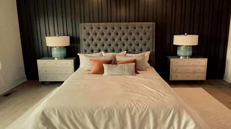 Black wood accent wall behind bed