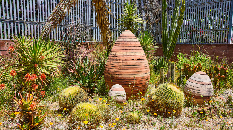 A desert garden with egg-shaped sculptures and succulents.