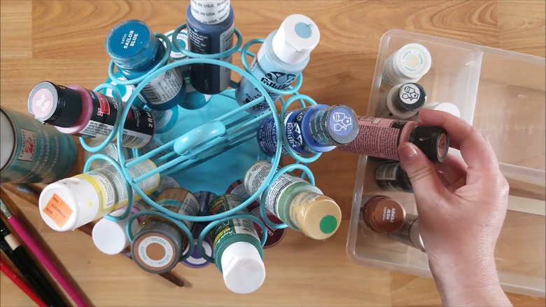 Top-down image of a hand filling up a blue Keurig coffee pod holder