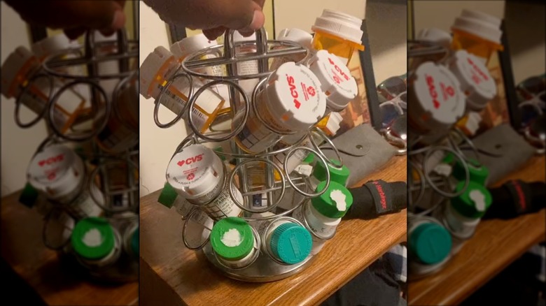 Medicine bottles arranged in a spinning K-cup holder on a bedside table