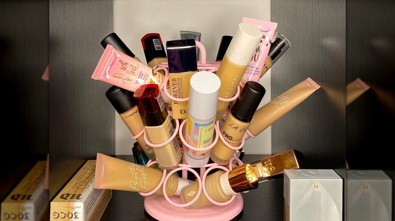 Black background with pink K-cup holder used to organize makeup tubes and bottles