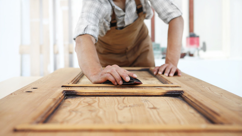 man sanding door
