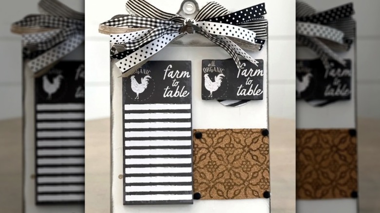 Decorative clipboard with ribbon holding notepad and small corkboard.