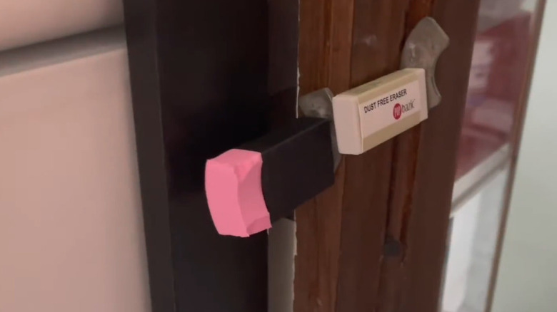 Rectangular white and pink erasers glued to door frame as a bumper.