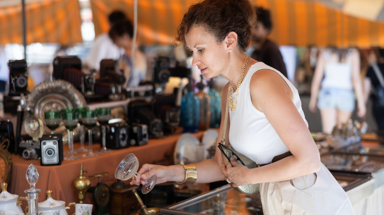 Woman shopping for glassware at flea market